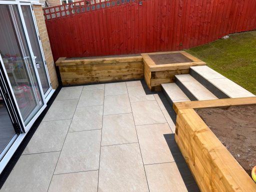 White Quartz Porcelain Patio – Bradford BD2 White quartz porcelain patio with timber raised beds and steps in Bradford BD2